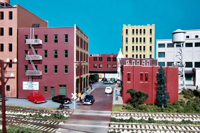 This two-lane brick side street ends at a four-lane concrete street.