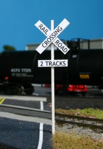 The scratchbuilt railroad crossing signs look great.