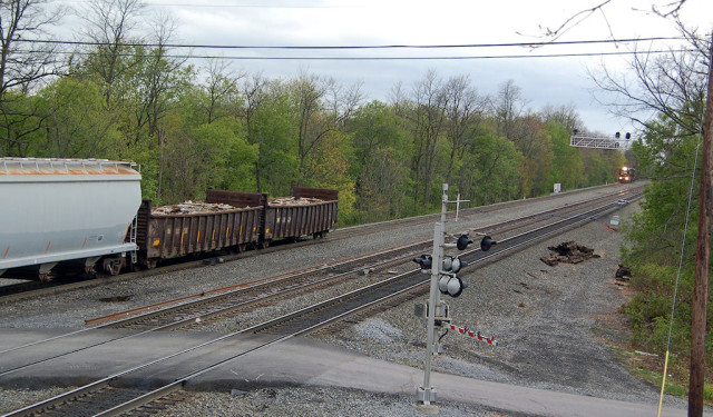 Note the helper set following closely behind a slow-moving east bound freight downward at the brick yard.