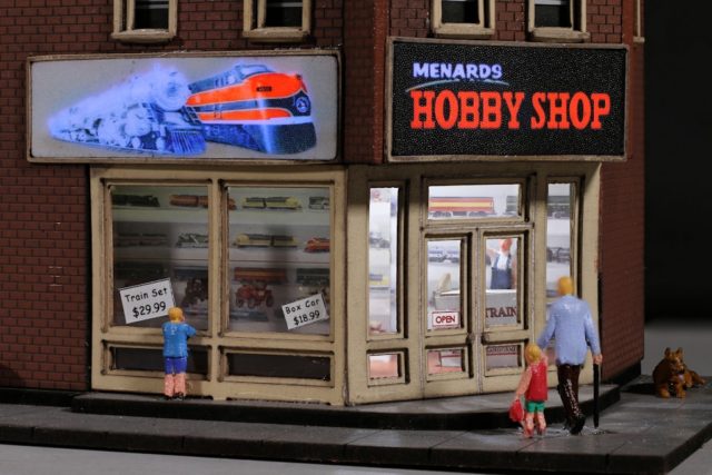 The Menard's Hobby Shop features two flashing signs and an illuminated interior.