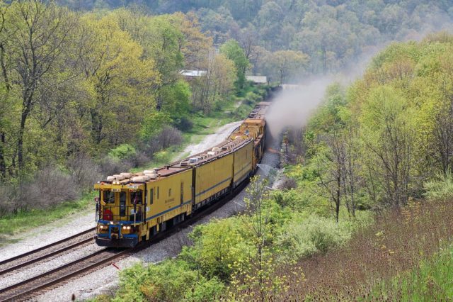 Rail grinder train hard at work at Meyersburg, Pennsylvania. Note the spray of water, soaking the vegetation ahead to the sparks from the grinding operation.